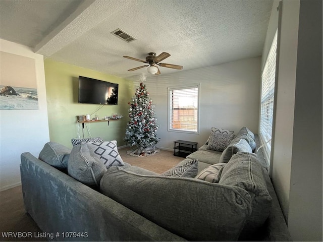 living area featuring baseboards, visible vents, ceiling fan, a textured ceiling, and carpet floors