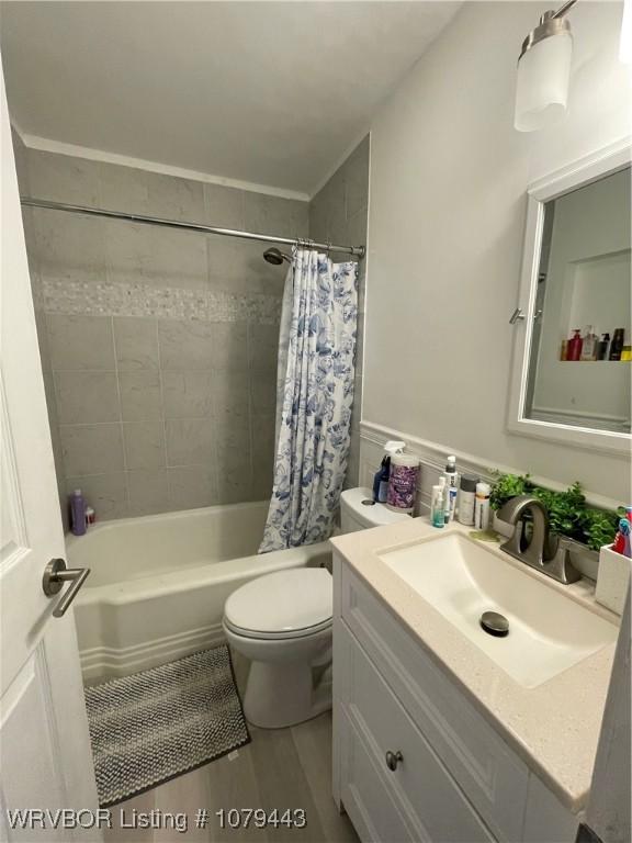 full bathroom featuring toilet, wood finished floors, shower / bath combination with curtain, and vanity