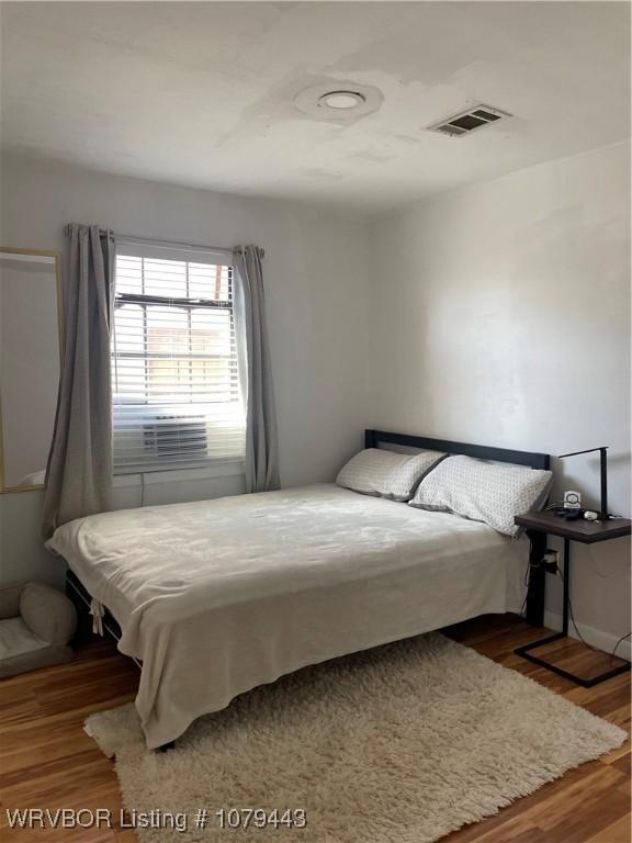 bedroom with wood finished floors and visible vents