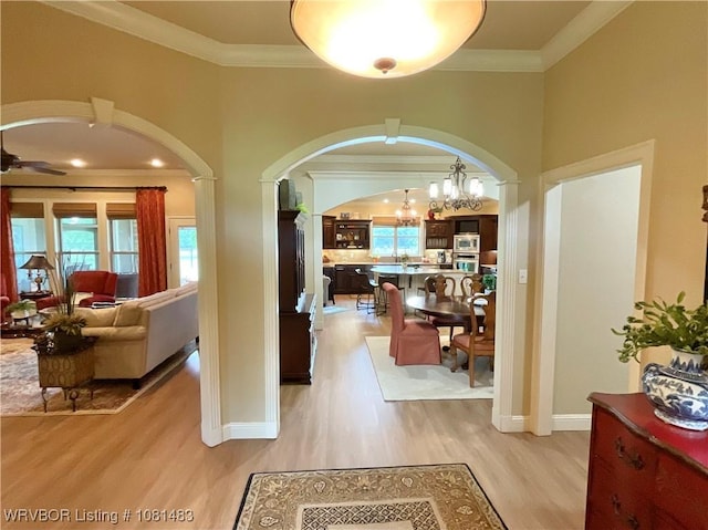 3414 Bugscuffle Rd, Lavaca, AR 72941 - hallway with arched walkways, crown molding, light wood finished floors, and a chandelier