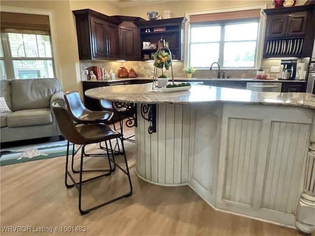 3414 Bugscuffle Rd, Lavaca, AR 72941 - kitchen with light wood-style flooring, a kitchen breakfast bar, crown molding, tasteful backsplash, and light stone counters
