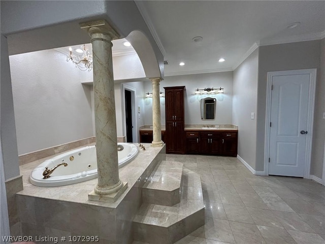 bathroom with ornate columns, ornamental molding, vanity, an inviting chandelier, and tiled bath