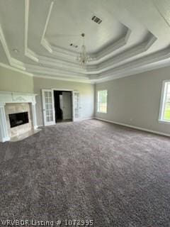 unfurnished living room with carpet, a tray ceiling, and ornamental molding