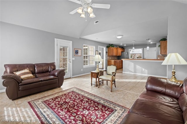 living room featuring light tile patterned floors, visible vents, a ceiling fan, high vaulted ceiling, and baseboards