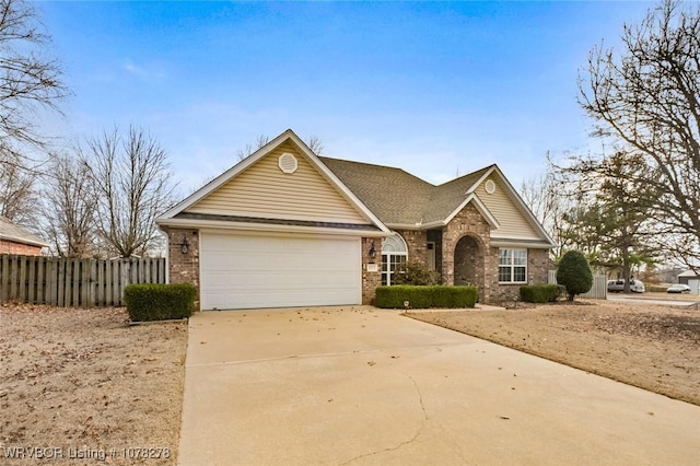 view of front of home with a garage, concrete driveway, brick siding, and fence