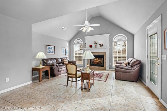 living room with a healthy amount of sunlight, visible vents, a tiled fireplace, and light tile patterned floors