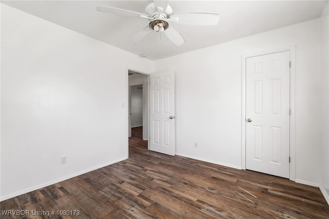 unfurnished bedroom featuring ceiling fan, baseboards, and dark wood-style floors