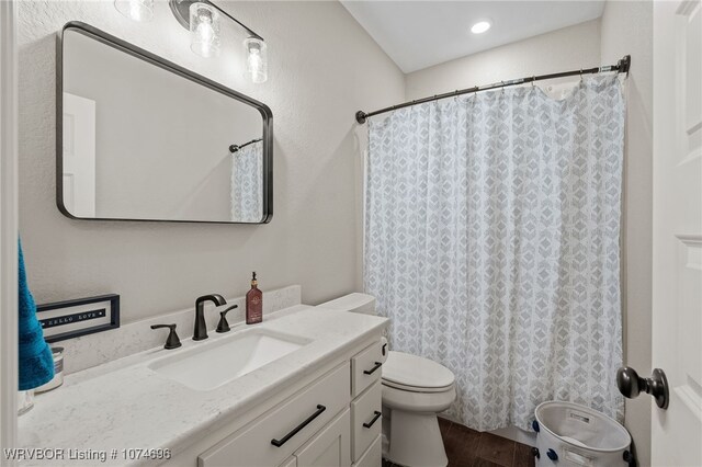 bathroom featuring toilet, vanity, and hardwood / wood-style flooring