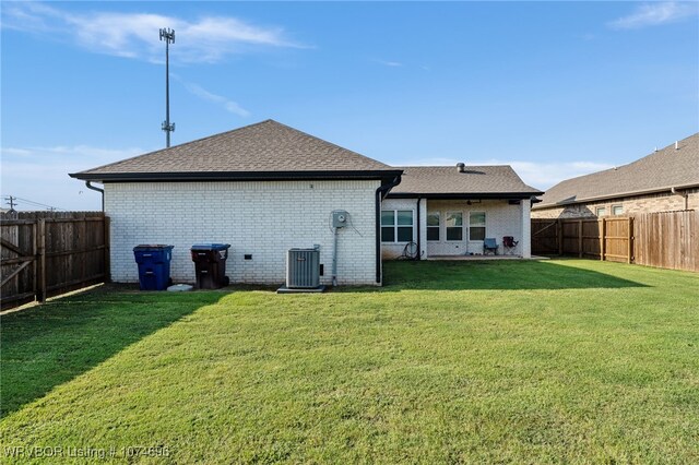 back of house with a yard and central AC unit