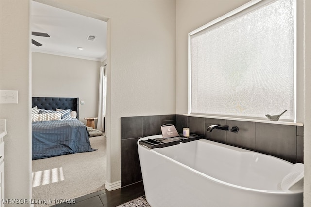 bathroom featuring a tub to relax in and ornamental molding