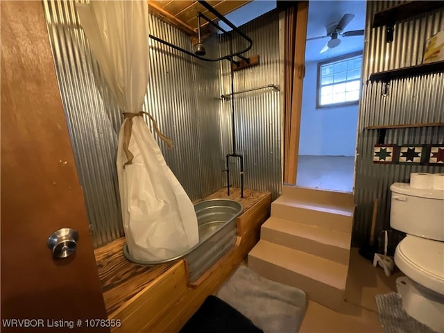 bathroom with ceiling fan, toilet, and a shower