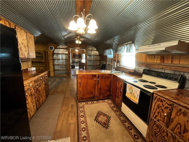 kitchen with electric stove, pendant lighting, ceiling fan with notable chandelier, and wooden walls