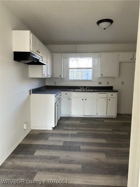 kitchen featuring sink, white cabinetry, a textured ceiling, and dark wood-type flooring