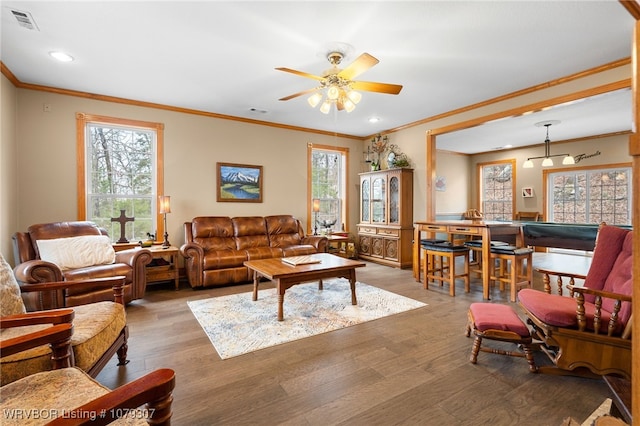 living room featuring a healthy amount of sunlight, visible vents, and wood finished floors