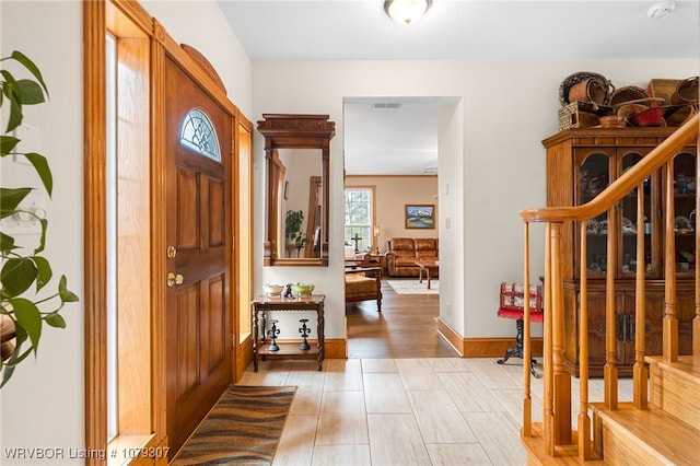 foyer featuring light wood-type flooring, visible vents, and baseboards