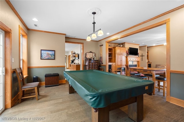 game room featuring crown molding, a fireplace, wood finished floors, and recessed lighting