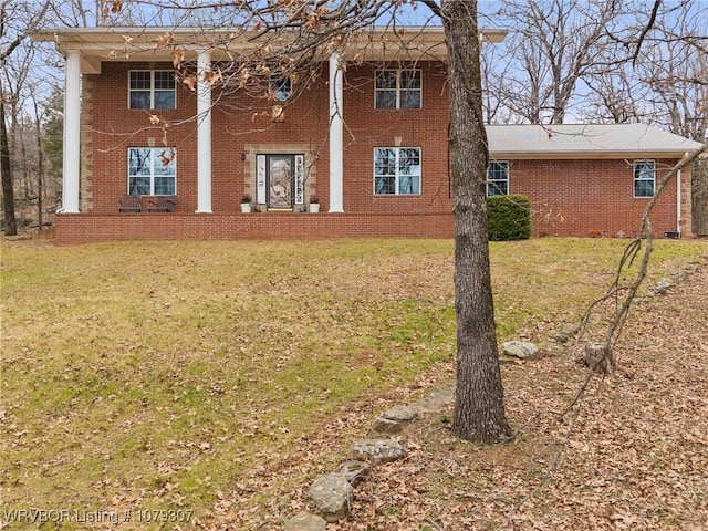 view of home's exterior featuring brick siding and a yard