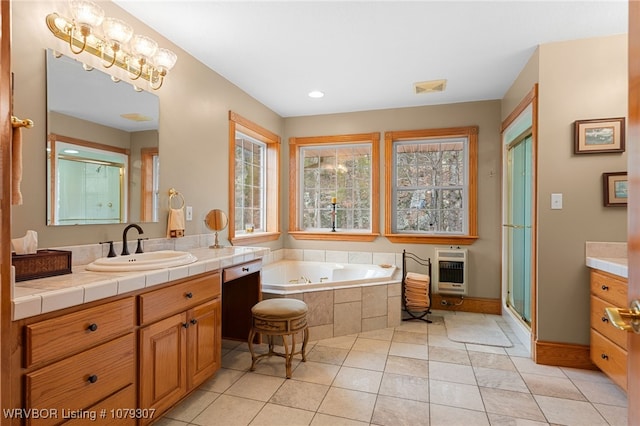 bathroom with tile patterned floors, heating unit, vanity, a shower stall, and a bath