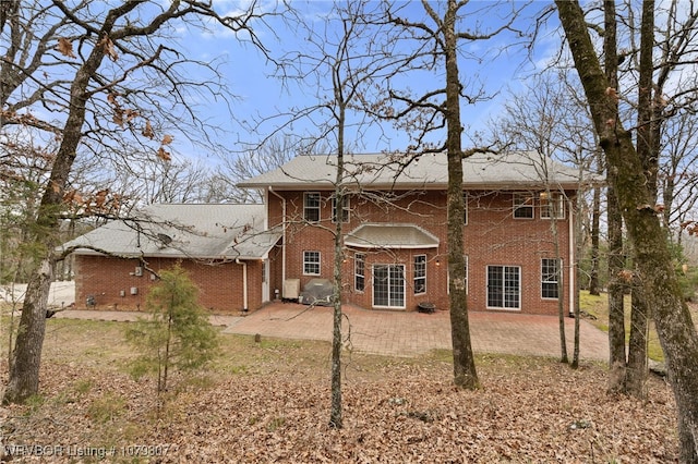 back of property featuring a patio and brick siding