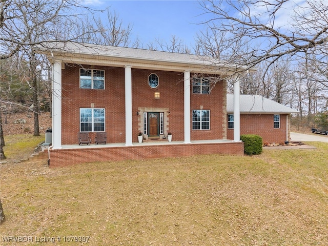 neoclassical / greek revival house featuring brick siding and a front lawn