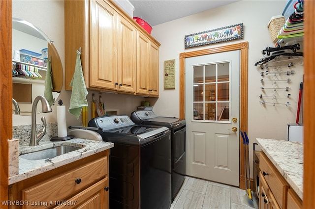 laundry room with a sink, wood finish floors, washing machine and clothes dryer, and cabinet space