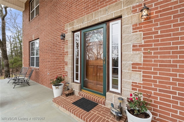 doorway to property featuring brick siding