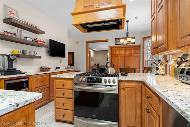 kitchen with appliances with stainless steel finishes, a peninsula, and light stone counters