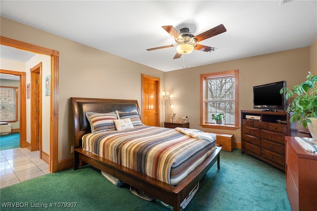 bedroom featuring light carpet, light tile patterned floors, ceiling fan, and baseboards