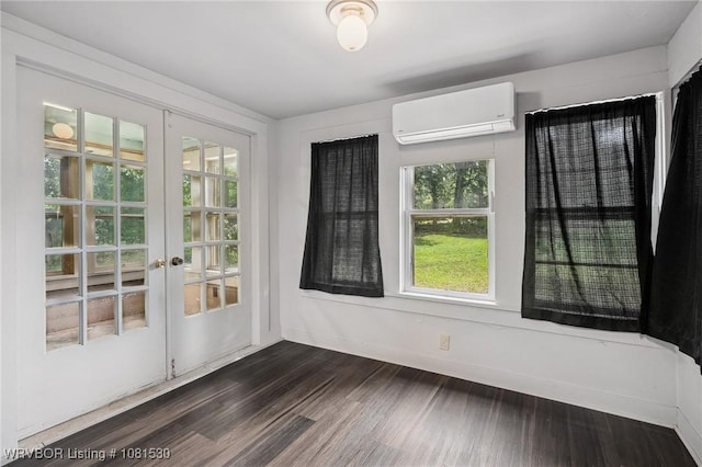 701 Witte St, Poteau, OK 74953 - spare room featuring a wall unit AC, french doors, and dark wood-type flooring
