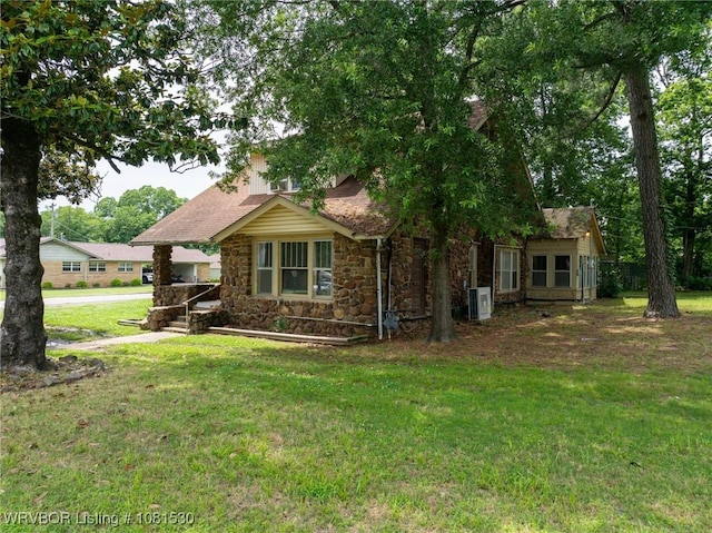 701 Witte St, Poteau, OK 74953 - view of side of home with stone siding, a yard, and roof with shingles
