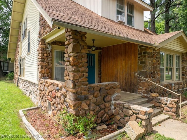 701 Witte St, Poteau, OK 74953 - property entrance featuring roof with shingles, stone siding, and cooling unit
