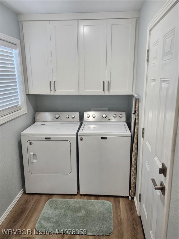 laundry area featuring cabinets, dark wood-type flooring, and washing machine and clothes dryer