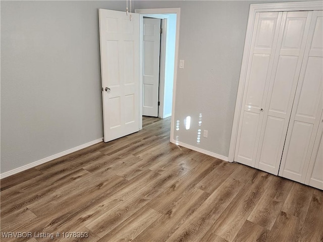 unfurnished bedroom with light hardwood / wood-style floors and a closet