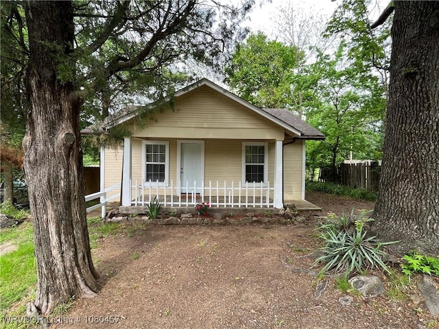 bungalow-style house with a porch and fence