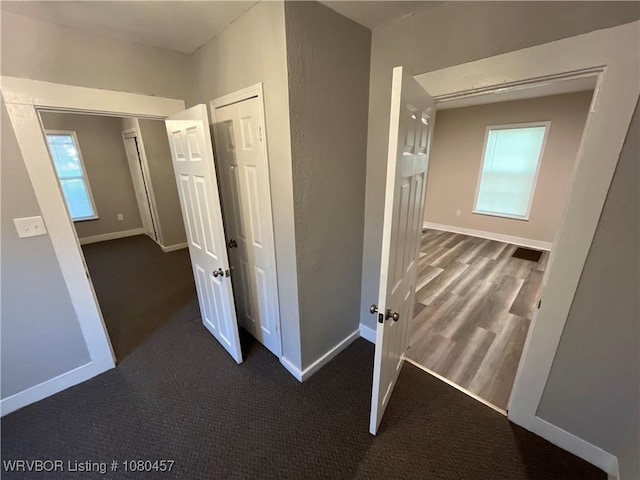 hallway featuring carpet flooring and baseboards