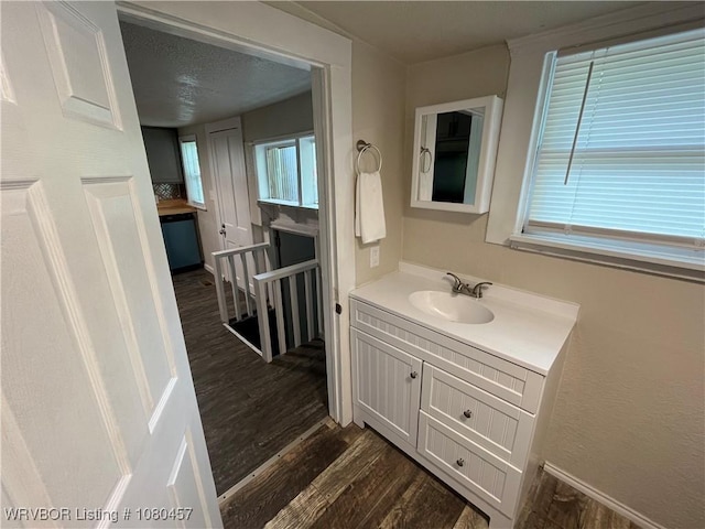 bathroom featuring wood finished floors, vanity, and baseboards