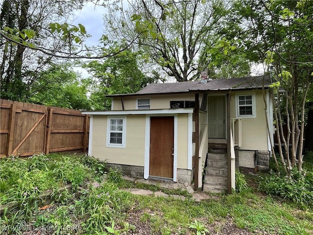 view of outdoor structure with fence and entry steps