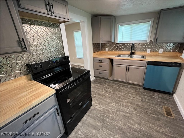 kitchen featuring a sink, black / electric stove, tasteful backsplash, visible vents, and dishwasher