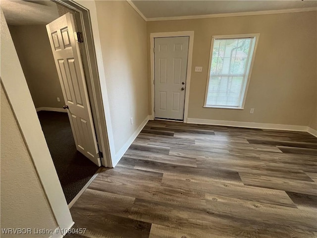 foyer with ornamental molding, dark wood finished floors, and baseboards