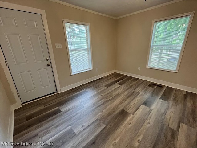 foyer entrance with dark wood-style flooring, a healthy amount of sunlight, crown molding, and baseboards