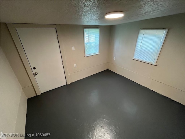 empty room with finished concrete flooring and a textured ceiling