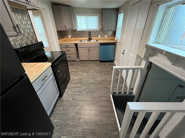 kitchen featuring a sink, wood counters, black range with electric stovetop, dishwashing machine, and gray cabinetry