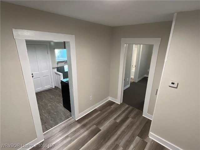 hall with baseboards and dark wood-style flooring