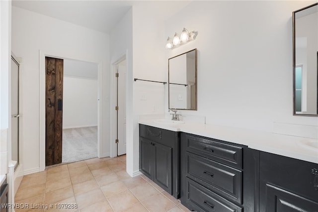 bathroom featuring double vanity, a sink, and tile patterned floors