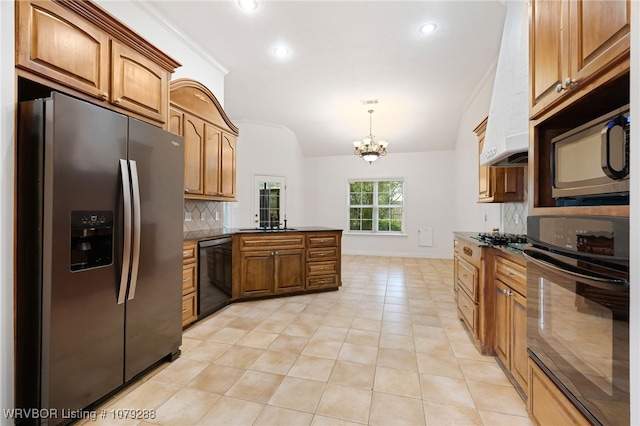 kitchen featuring lofted ceiling, a peninsula, brown cabinets, black appliances, and tasteful backsplash