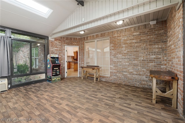 unfurnished sunroom featuring vaulted ceiling with skylight and a wall unit AC