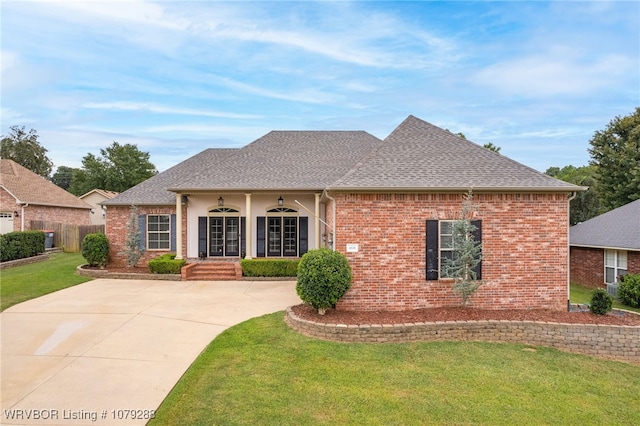 view of front of home with brick siding, roof with shingles, and a front yard