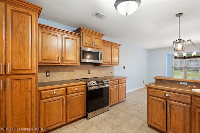 2117 Parkway Cir, Van Buren, AR 72956 - kitchen featuring appliances with stainless steel finishes, decorative backsplash, dark countertops, brown cabinetry, and light tile patterned floors