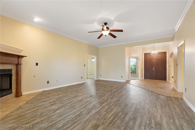 2117 Parkway Cir, Van Buren, AR 72956 - unfurnished living room featuring ceiling fan, wood finished floors, a tiled fireplace, crown molding, and baseboards