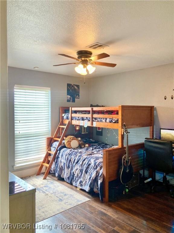 102437 S 4620th Rd, Sallisaw, OK 74955 - bedroom featuring hardwood / wood-style flooring, a textured ceiling, and ceiling fan